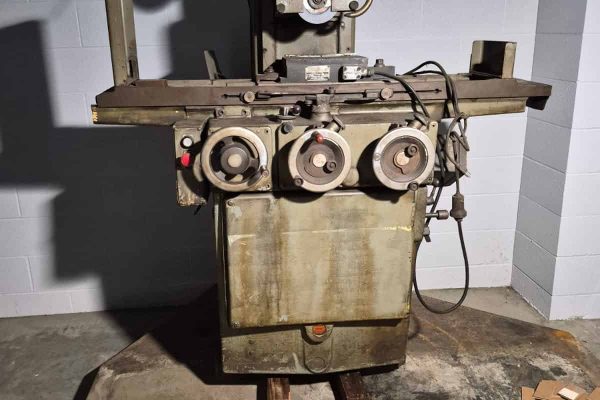 Vintage industrial metalworking machine with control dials and electrical components.