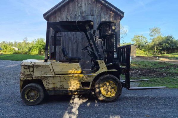 Used forklift with black mast and yellow body, showing signs of wear and rust.