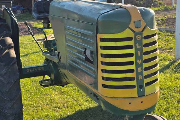 Oliver 77 tractor with green body and yellow grille, vintage farm equipment.