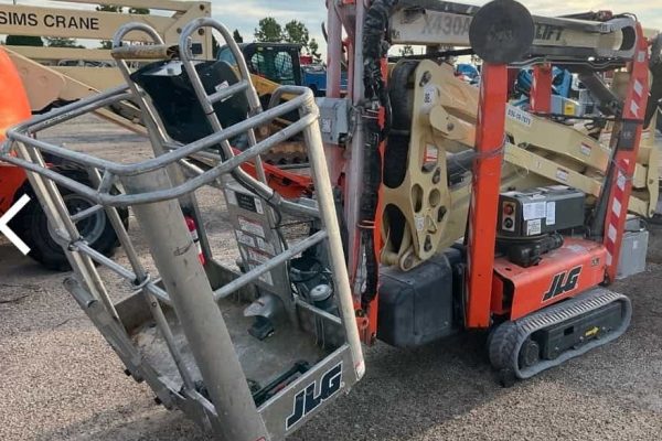 JLG 1930ES electric scissor lift, compact aerial work platform for indoor and outdoor use, in a construction yard.