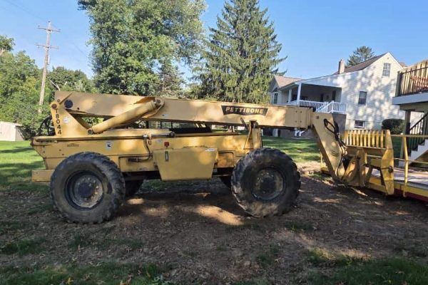 2006 Pettibone T8044 telehandler with extended boom and large tires in a yard.